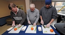 3 men chopping vegetables
